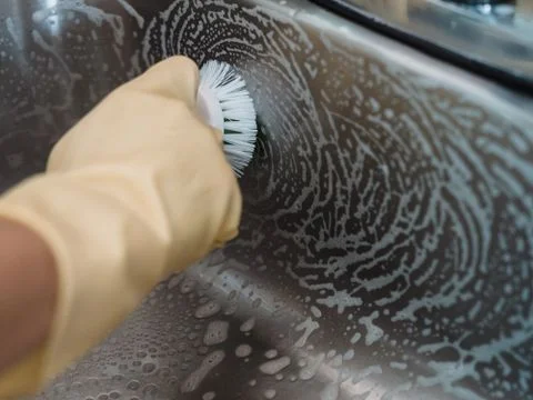 Carbon and sludge being scraped out of an emptied commercial fryer vat