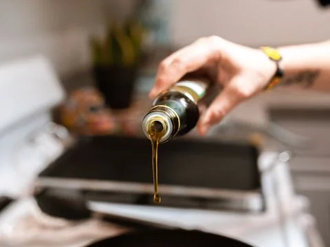 Fresh cooking oil being poured into a cleaned commercial fryer vat to the correct level