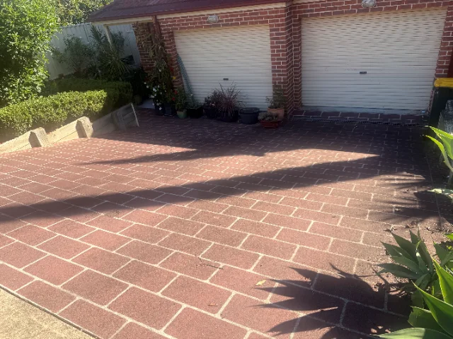 Brick paved driveway and its garage approach after pressure cleaning, the paver faces even and the joints back to pale grey